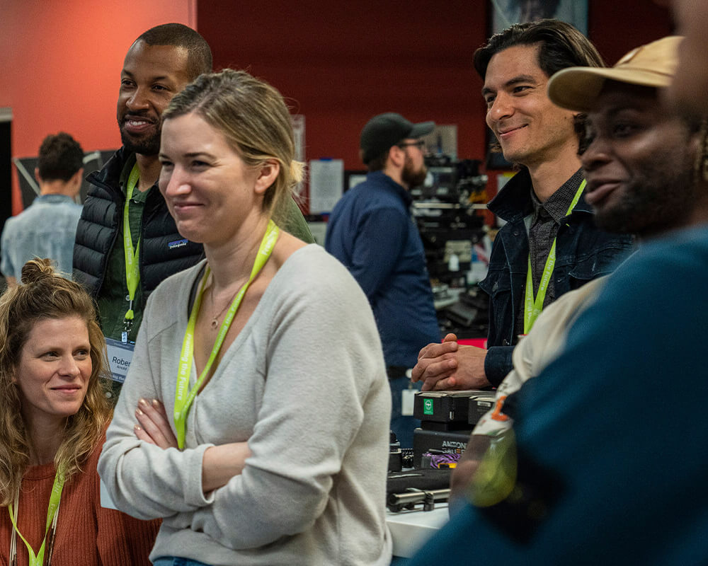 Filmmakers smile as they stand in a prep bay looking on at a demonstration